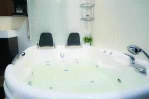 y baño con bañera y 2 sillas. en Azur House2, en Cluj-Napoca 15 fotos más