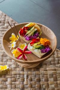 乌布Gypsy Lust Ubud的盘子里放着两个三明治，桌子上放着一束鲜花 更多55张照片