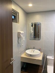 a bathroom with a sink and a mirror at Lumia Hotel in Ho Chi Minh City