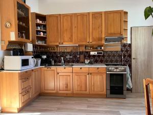 a kitchen with wooden cabinets and a white microwave at Prázdninový dům Šternberk in Šternberk