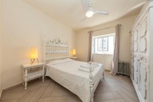 a white bedroom with a white bed and a window at Lagos Center Apartment in Lagos