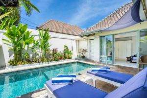 a villa with a swimming pool and a house at Villa Waterlily A Sanur in Sanur