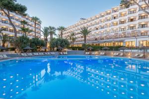 a hotel swimming pool with a large building in the background at Leonardo Royal Hotel Ibiza Santa Eulalia in Es Cana