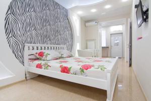 a bedroom with a white bed with flowers on it at Apartment on Sadovaya in Odesa