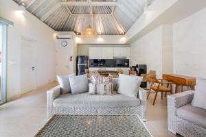 a living room with a couch and a table at Villa Waterlily A Sanur in Sanur