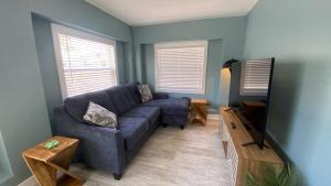 ein Wohnzimmer mit einer blauen Couch und einem Fernseher in der Unterkunft Ringling Cottage in Bailey Hall