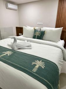 a bed with a green and white blanket on it at Matra Apartment in Canggu