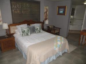 a bedroom with a large bed with pillows on it at Dandelion Cottage 