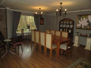 a dining room with a table and chairs and a dining room at Dandelion Cottage in Boschkop