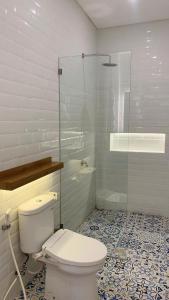 a bathroom with a toilet and a glass shower at Matra Apartment in Canggu