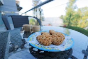 two cookies sitting on a plate on a table at Marine Villa - Valley View l Swimming pool l AC in Panchgani