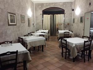 un restaurante con mesas con manteles blancos en Affittacamere Da Franco, en Parma