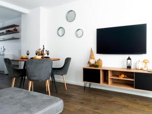 sala de estar con mesa y TV en la pared en Urbanes Nest Lübeck, en Lübeck