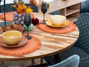 Una mesa de madera con platos y copas de vino encima. en Urbanes Nest Lübeck, en Lübeck
