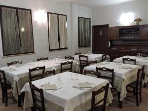 a dining room with tables with white tablecloths and a piano at Affittacamere Da Franco in Parma