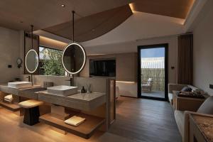 een badkamer met twee wastafels en een grote spiegel bij Huazhu Luxurious Mountain Courtyard Private Hot Spring Resort in Longmen +112 foto's