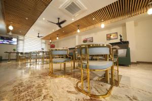 a restaurant with chairs and a table and a piano at Elight Inn Hotel in Jaipur