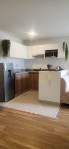 a kitchen with a refrigerator and a counter top at Depa UMBRA, one block from Rebagliati Hospital in Lima