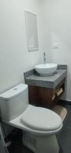 a bathroom with a white toilet and a sink at Depa UMBRA, one block from Rebagliati Hospital in Lima