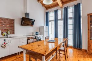 a kitchen with a wooden table with chairs and a table at A ver Lisboa 3 in Porto Brandão