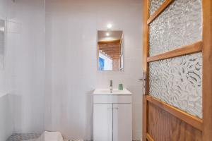 a bathroom with a sink and a wooden door at A ver Lisboa 3 in Porto Brandão +20 photos