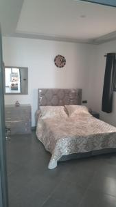 a bedroom with a bed and a clock on the wall at Riad Villa Nice Tagadirt, Agadir in Agadir