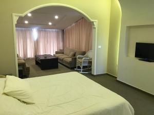 ein Schlafzimmer mit Bett und ein Wohnzimmer in der Unterkunft Platinum Hotel in Tyros