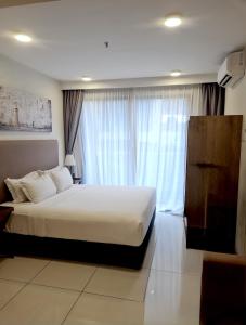 a bedroom with a white bed and a large window at Timurbay Residences in Kuantan