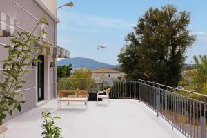 un patio con due sedie e un tavolo su un balcone di Avia a Città di Corfù
