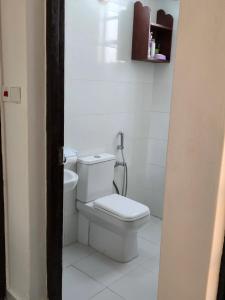 - une salle de bains avec toilettes dans une chambre blanche dans l'établissement Charming chalet Diani, à Diani Beach
