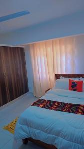 une chambre avec un grand lit et une fenêtre dans l'établissement Charming chalet Diani, à Diani Beach