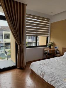 a bedroom with a bed and a large window at Kimi Homestay Hue in Thôn Trường Giang
