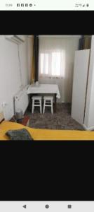 a room with a white table and a white refrigerator at Garsoniere in Târgu Jiu