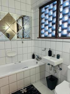 a bathroom with a tub and a sink and a toilet at Casa Myla, 2 Kuiseb Street, Windhoek in Windhoek
