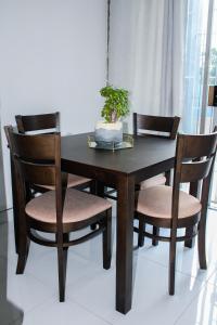 a wooden table with two chairs and a plant on it at Casa Myla, 2 Kuiseb Street, Windhoek in Windhoek