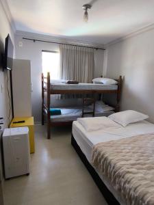 a bedroom with two bunk beds and a window at Lindo espaço de lazer in Cascavel
