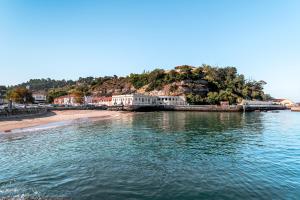 a body of water next to a beach with houses at A ver Lisboa 3 in Porto Brandão