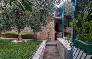 a bench in a garden with a tree and a fireplace at Nice Apartment In Duce With House Sea View in Duće