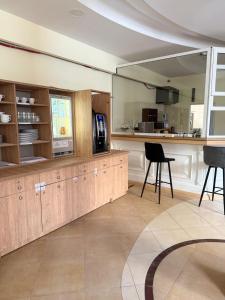 a kitchen with wooden cabinets and a counter with chairs at Kameralny Hotel TM in Radom +21 photos