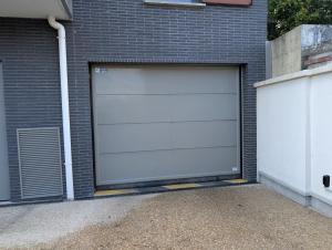 a white garage door on the side of a brick building at Candyland-20min Disney-Famille in Meaux