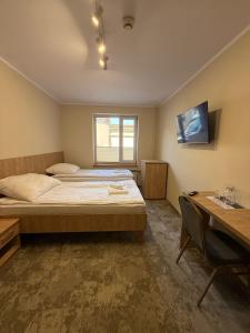 a bedroom with a bed and a desk and a television at Kameralny Hotel TM in Radom +21 photos