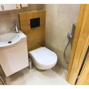 a small bathroom with a toilet and a sink at Studio LOFT right in the center in Skorka