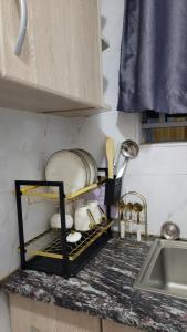 - un comptoir de cuisine avec une étagère et de la vaisselle dans l'établissement Jakima studios Ruaka, à Ruaka