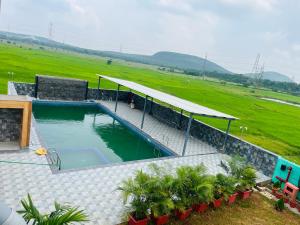 a swimming pool in the middle of a field at Anjana Resort and Convention in Bhubaneshwar