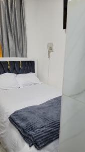 une chambre avec un lit avec une couverture noire dessus dans l'établissement Jakima studios Ruaka, à Ruaka