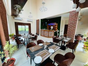 a restaurant with tables and chairs in a room at Anjana Resort and Convention in Bhubaneshwar +7 photos