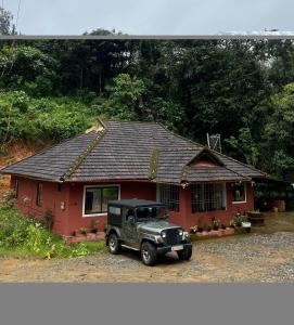 a truck parked in front of a red house at The Aurora Coorg in Madikeri +6 photos
