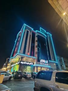 un edificio con auto parcheggiate di fronte ad esso di notte di المهاجر فرع قريش a Gedda