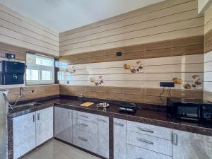 a kitchen with a sink and a microwave at RK Homes Service Apartments in Sancoale