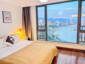 a bedroom with a bed and a large window at Chongqing Yifang B&B in Nan'an